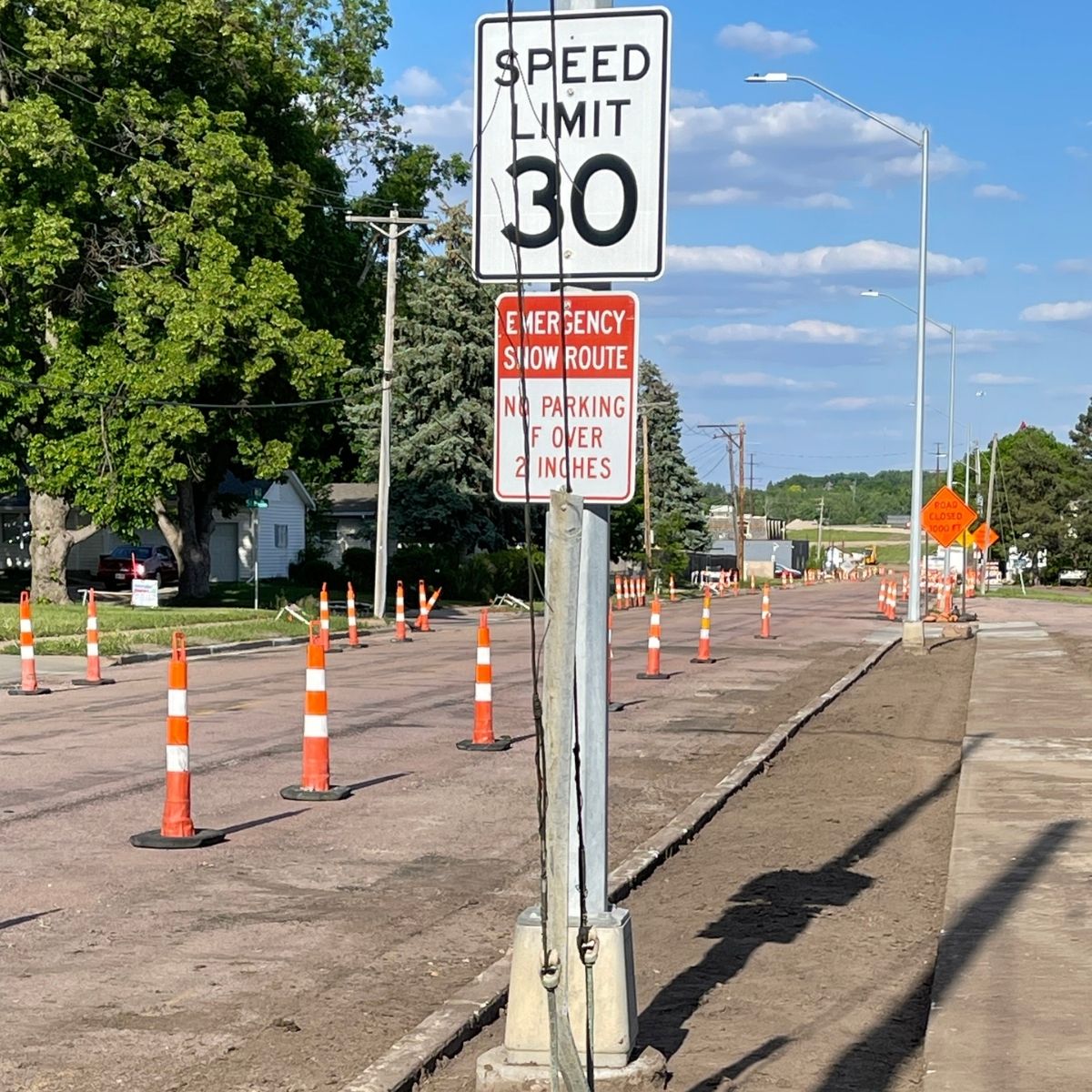 Orange traffic cones along 41st Street beside a bare boulevard outside Roxi & Co in Sioux Falls.