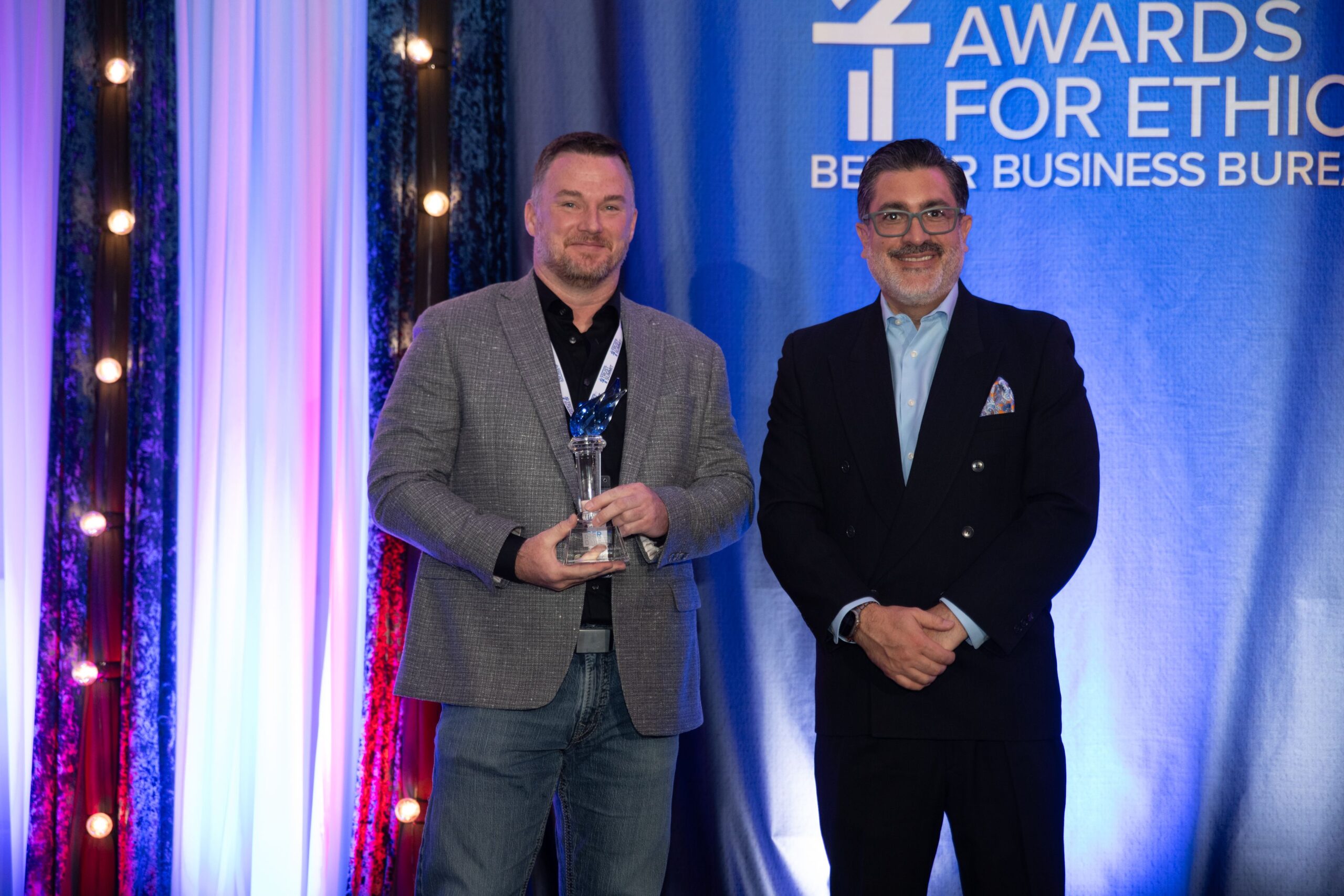 Roxi & Co owner Telly Rollinger holding the 2026 BBB International Torch Award at the awards ceremony in Denver.