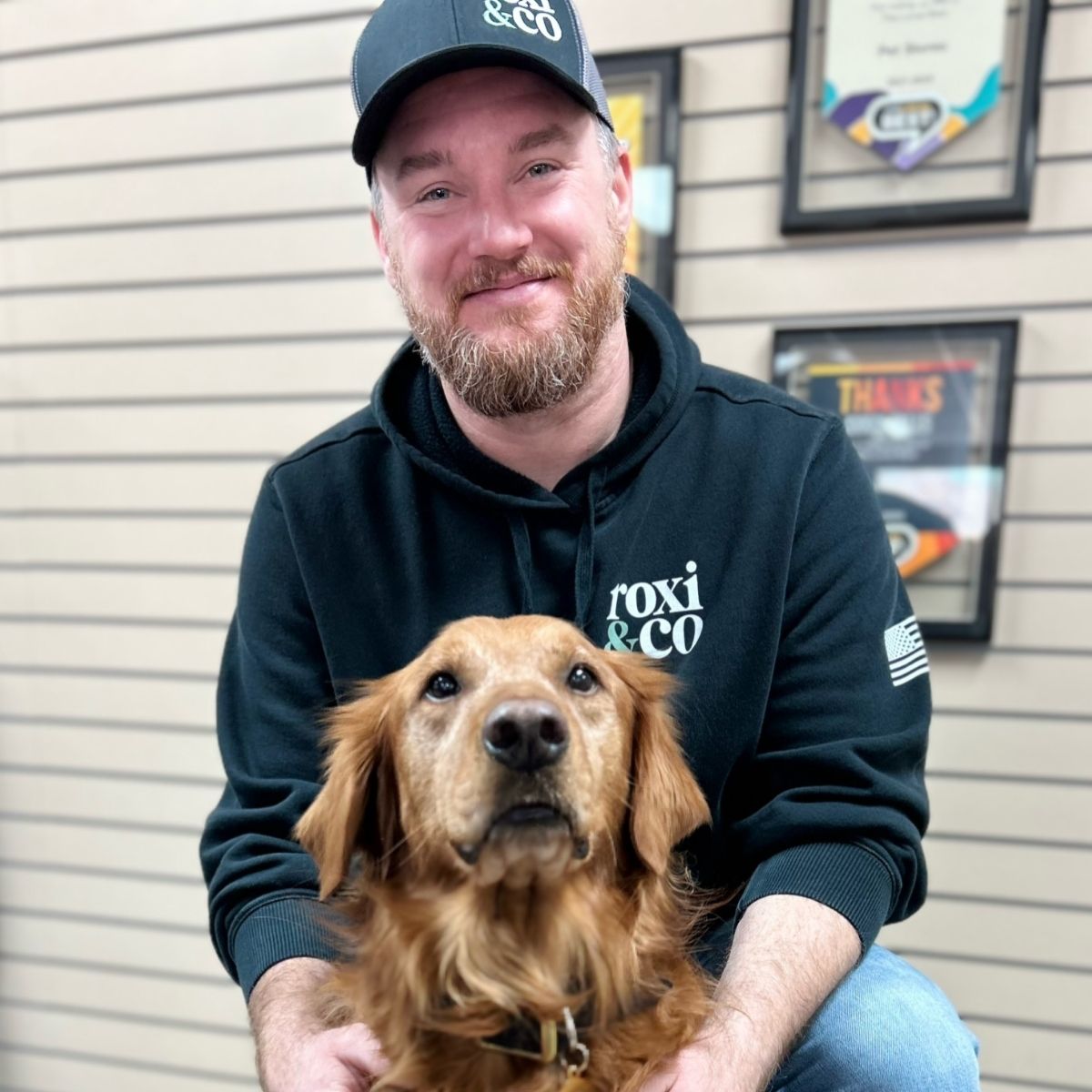 Roxi & Co owner Telly Rollinger with Cash, a golden retriever, inside the store.